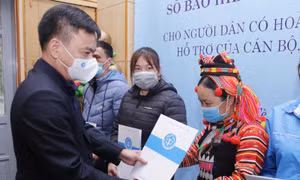 Phó Giám đốc BHXH tỉnh Lai Châu, Dương Quốc Tuấn trao sổ BHXH và thẻ BHYT cho các hộ dân nghèo có hoàn cảnh đặc biệt khó khăn của huyện biên giới Mường Tè (Lai Châu)