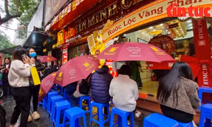 Người dân 'đội' mưa lạnh xếp hàng mua vàng trước ngày vía Thần Tài