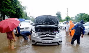 Hà Nội: Người dân kê gạch chống ngập nước cho ô tô sau cơn mưa lớn