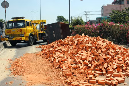 Xe ben ép xe tải chở gạch lật nhào trên QL1 ảnh 1