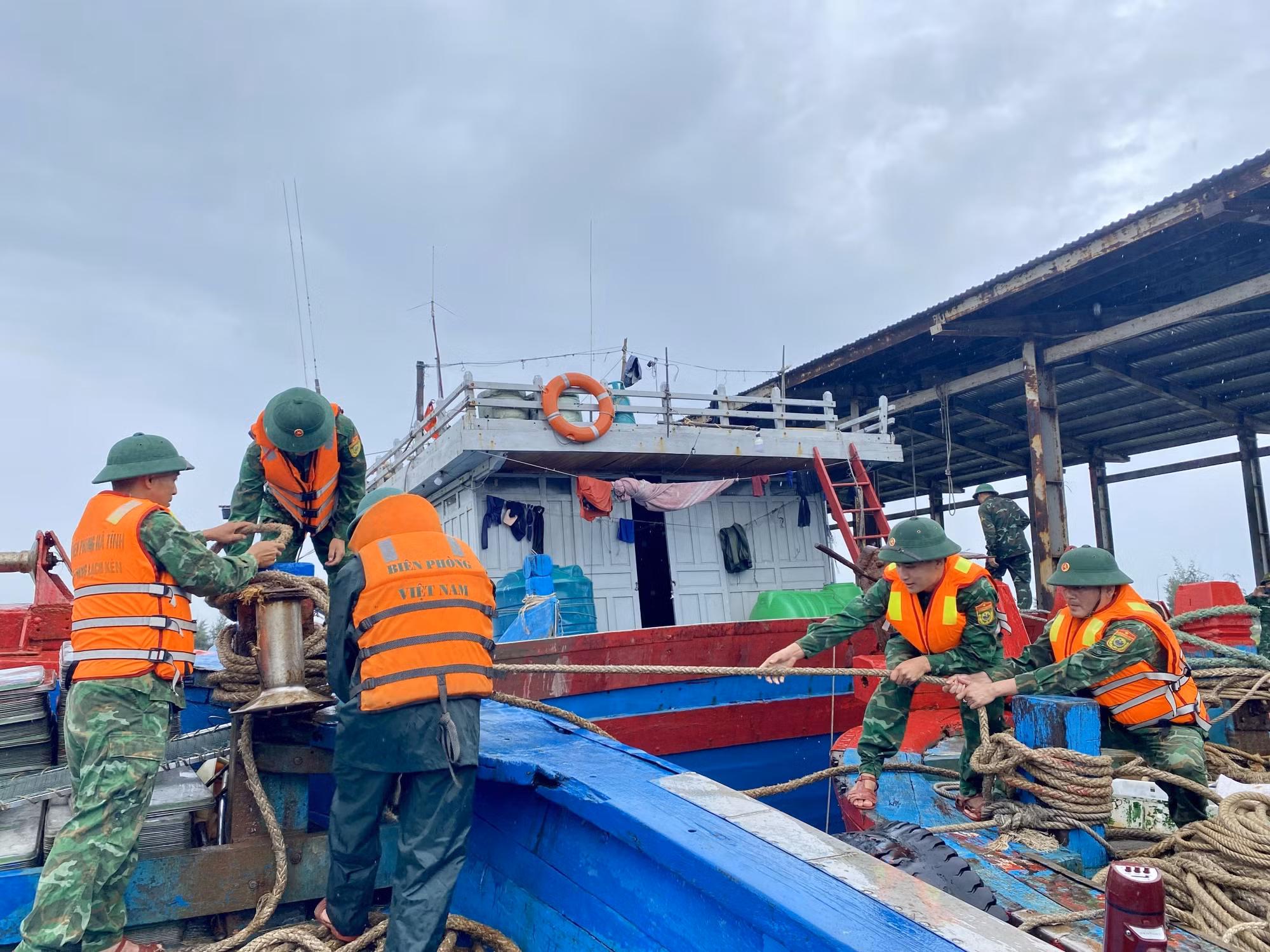 Bộ đội biên phòng hỗ trợ ngư dân gia cố, chằng néo tàu thuyền.