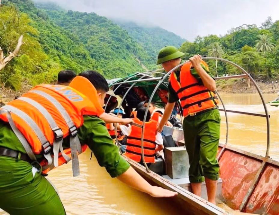 Lực lượng công an đưa, đón học sinh và giáo viên qua sông Nậm Nơn bằng thuyền khi cầu treo bản Xốp Mạt bị lũ cuốn trôi trong trận mưa bão cuối tháng 7 vừa qua. Ảnh: TTXVN phát