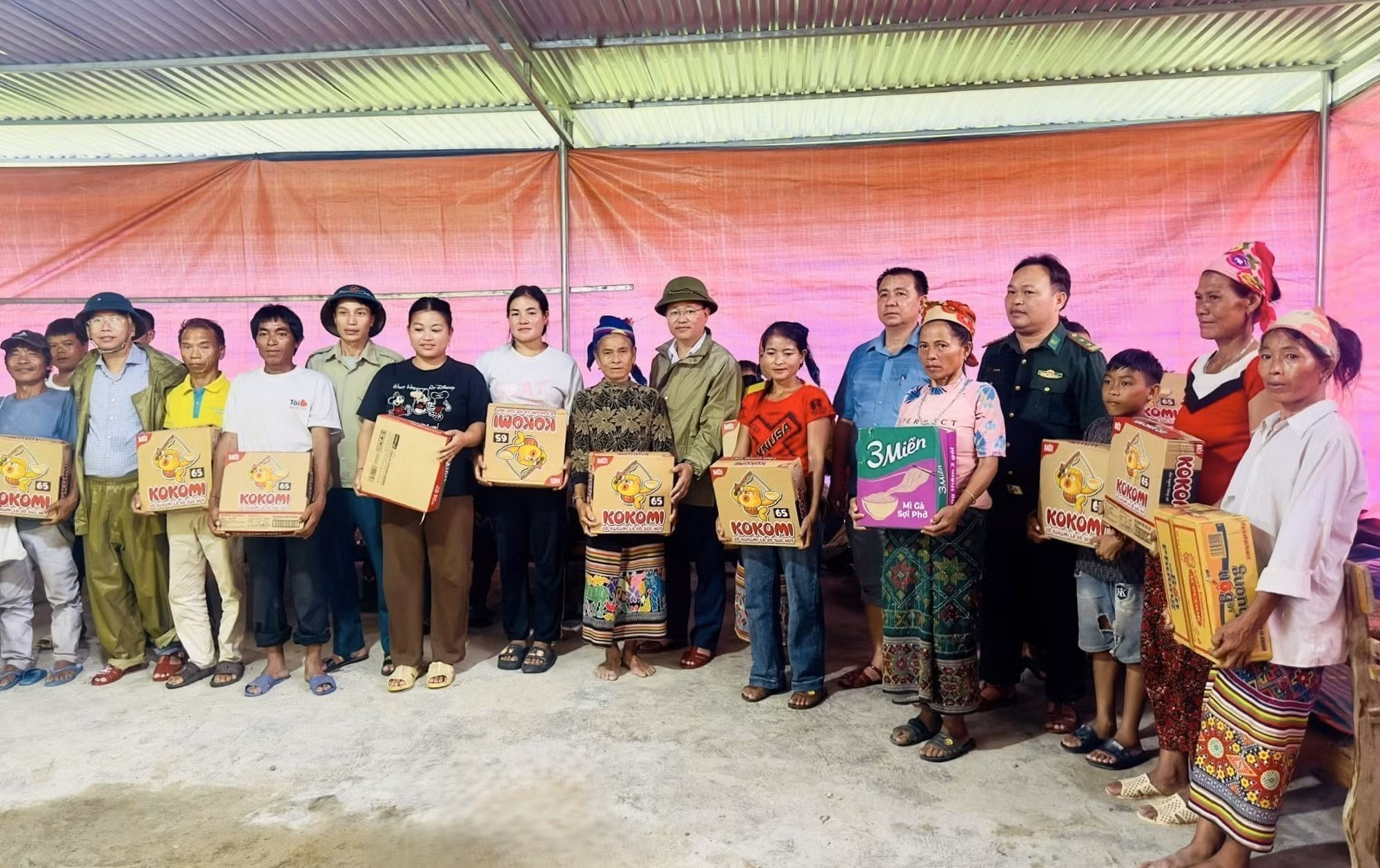 Lãnh đạo chính quyền địa phương trao các nhu yếu phẩm cho người dân di dời đến nơi ở tạm. Ảnh: TTXVN phát