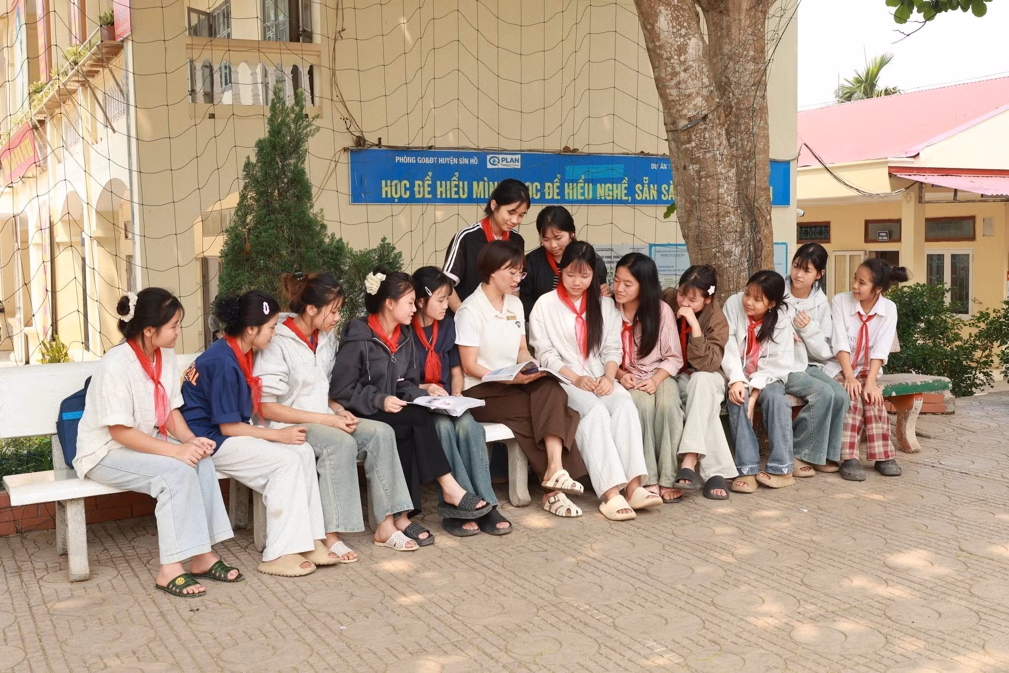 Học sinh và cô giáo chia sẻ về vấn đề tảo hôn trong giờ ra chơi tại Trường Trung học cơ sở Noong Hẻo, xã Pu Sam Cáp.