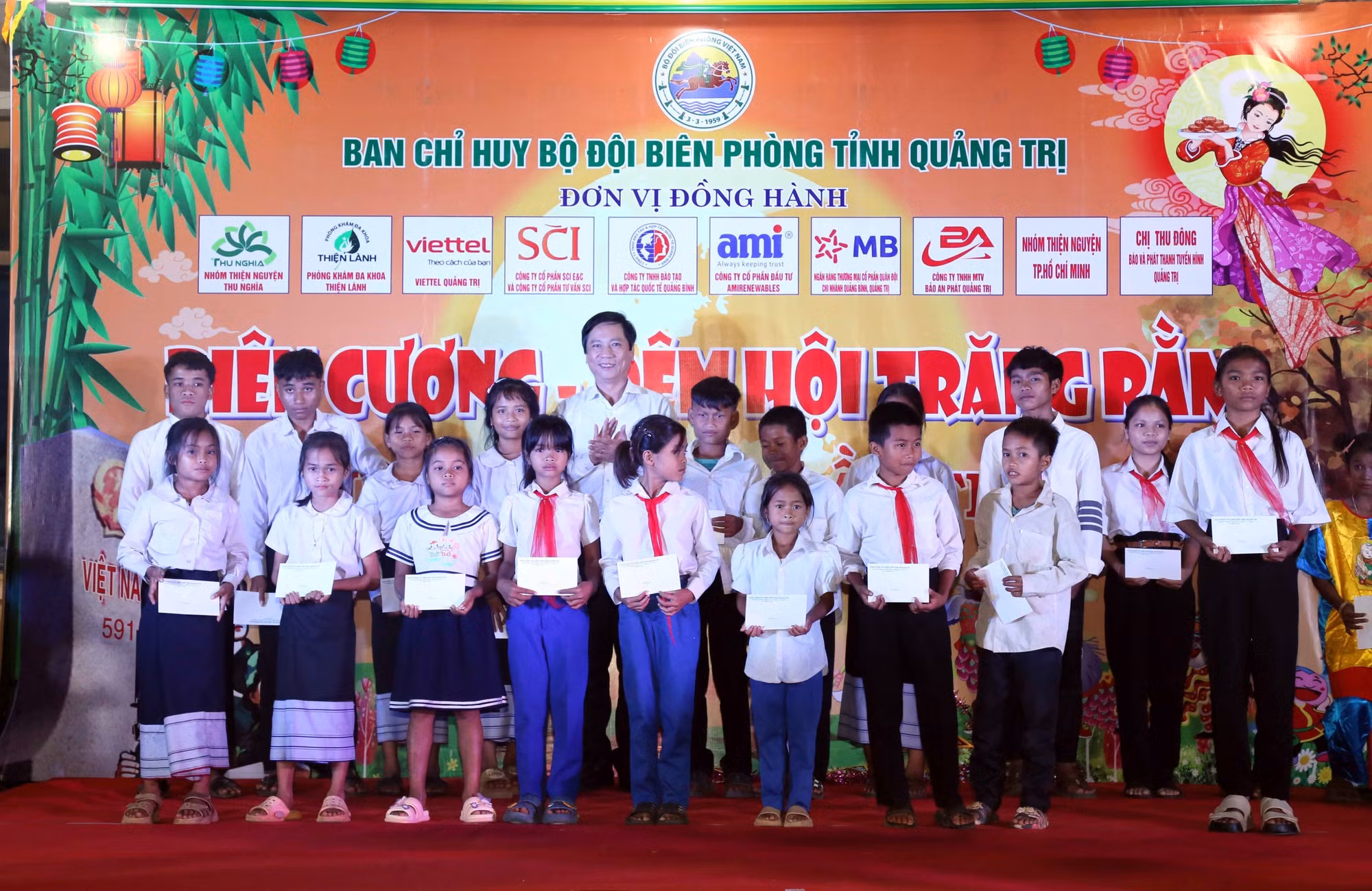 Phó Chủ tịch Thường trực UBND tỉnh Quảng Trị Hoàng Nam trao tặng học bổng cho các em thiếu nhi tại chương trình. Ảnh: Tá Chuyên/TTXVN