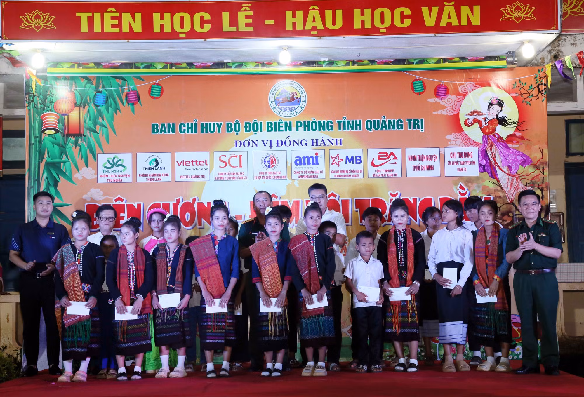 Lãnh đạo Chỉ huy Bộ đội biên phòng Quảng Trị và các đơn vị tài trợ tặng học bổng cho các em học sinh Việt Nam và Lào tại chương trình. Ảnh: Tá Chuyên/TTXVN