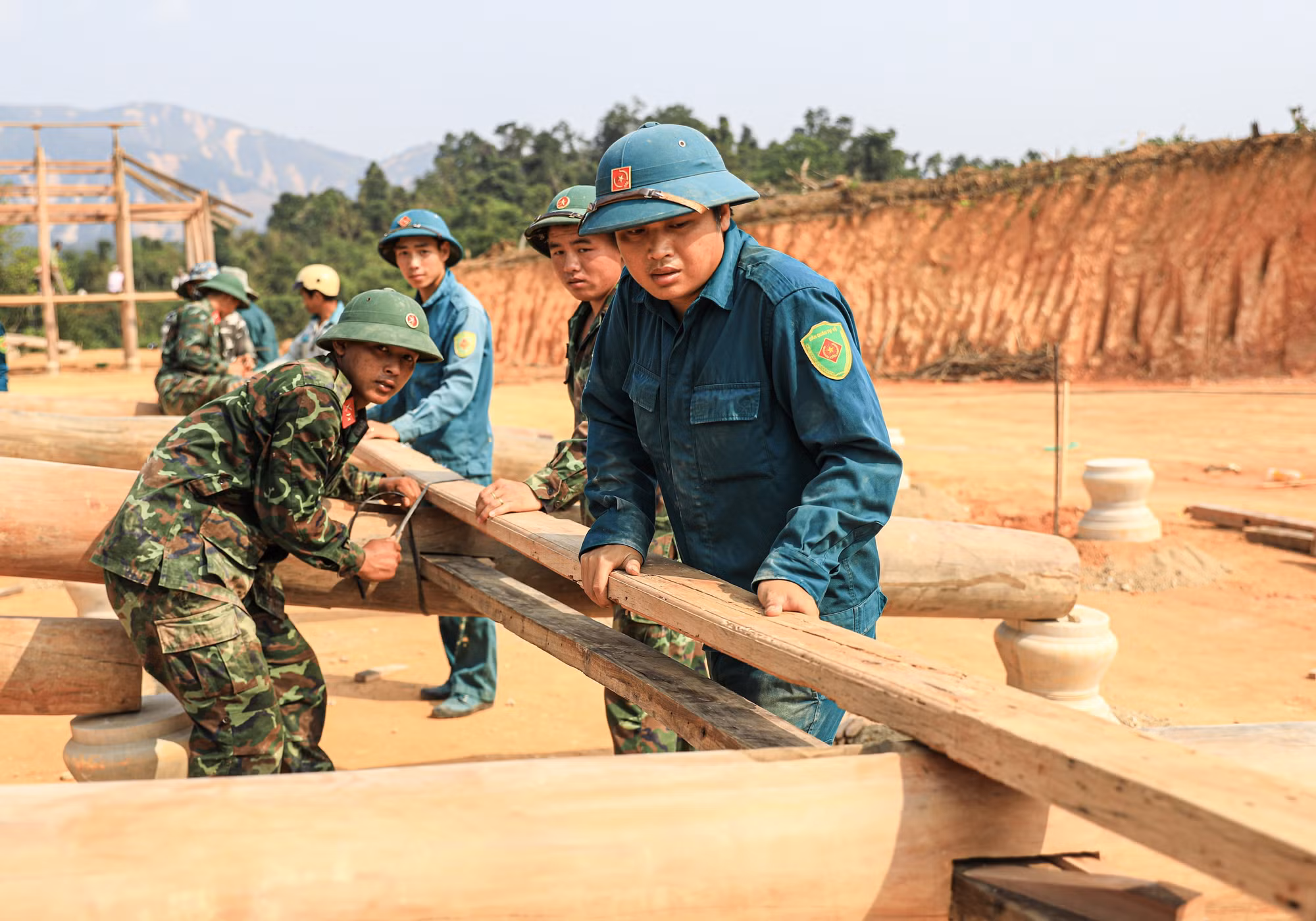 Lực lượng bộ đội và dân quân tự vệ giúp dân dựng nhà sàn ở bản Mường Pồn 2.