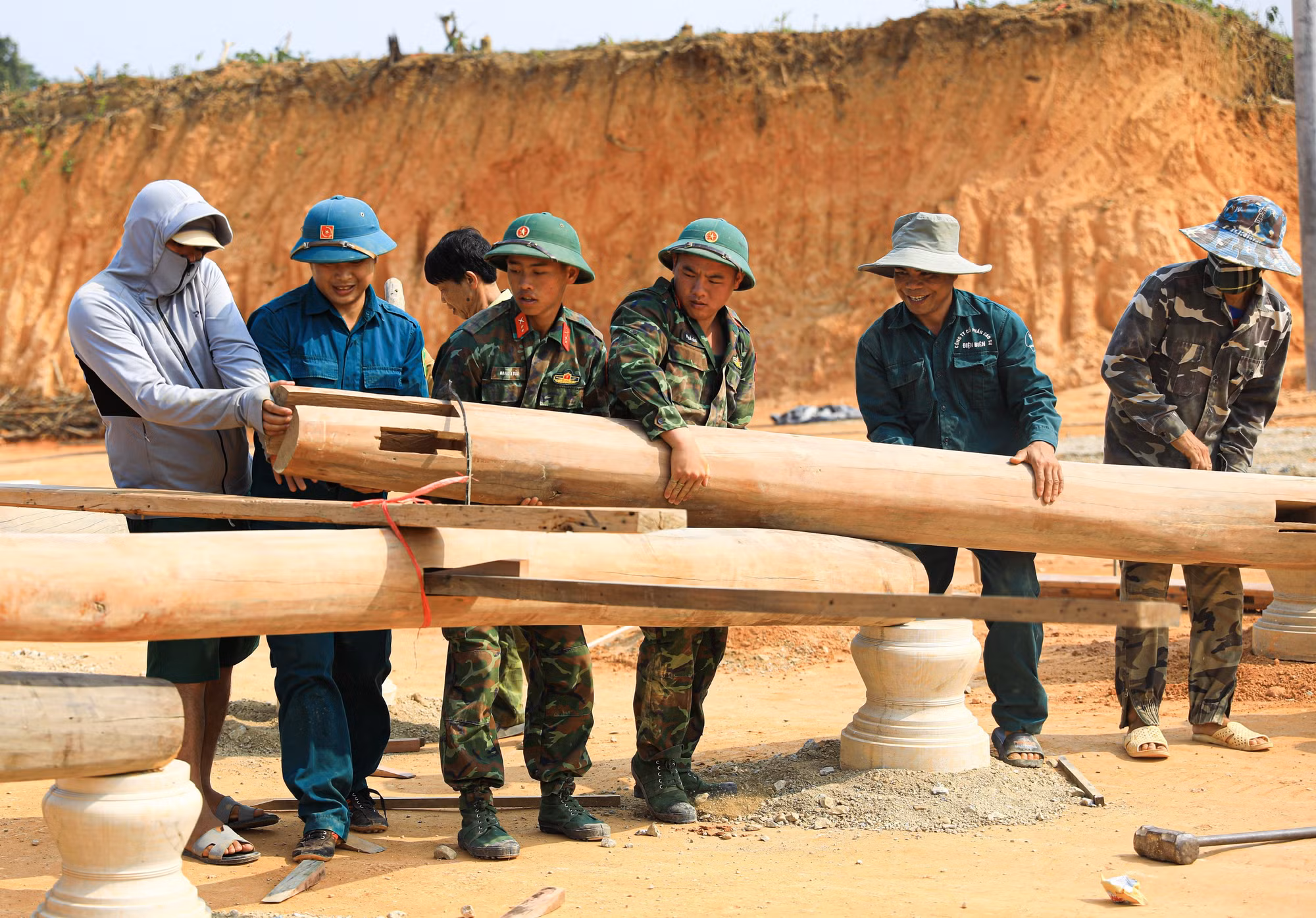Lực lượng bộ đội và dân quân tự vệ giúp dân dựng nhà sàn ở bản Mường Pồn 2.