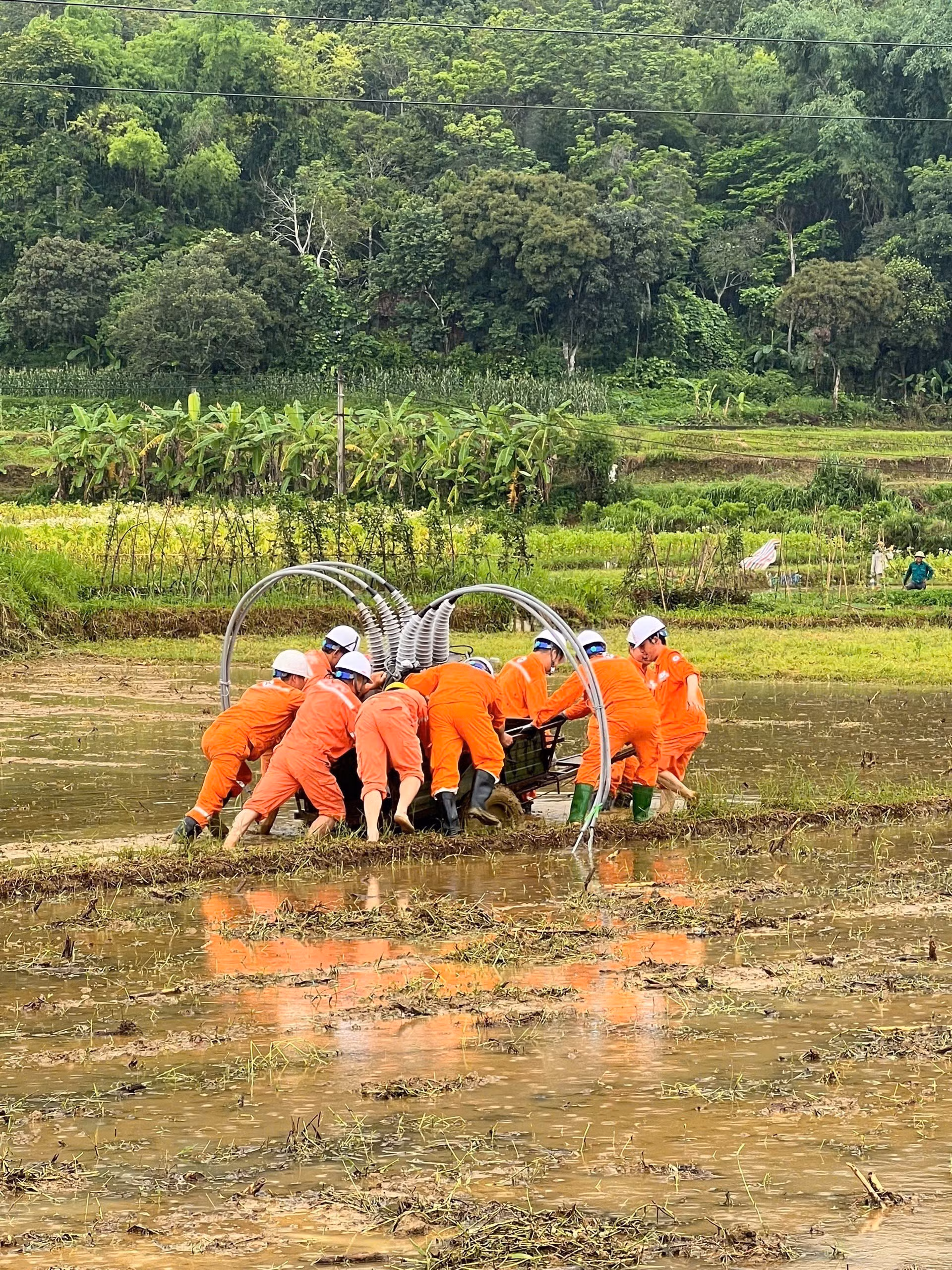 Công nhân điện lực Cao Bằng vận chuyển thiết bị điện đến hiện trường để thay thế những thiết bị bị hư hại. Ảnh: TTXVN phát