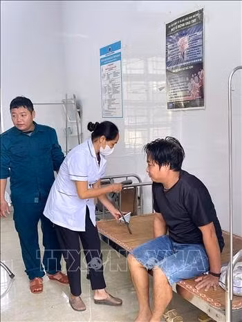 Người dân bị mắc kẹt trong hang được đưa về trạm y tế xã để kiểm tra sức khỏe. Ảnh: TTXVN phát