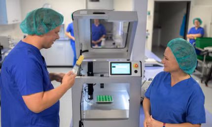 Hai nhà nghiên cứu giới thiệu máy in 3D sản xuất dược phẩm tại một phòng lab ở Oldenburg, Đức. Ảnh: DPA