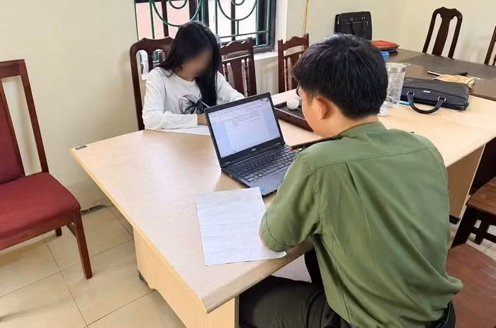 Cán bộ Phòng An ninh mạng làm việc với L.T.C. Ảnh: Công an cung cấp.