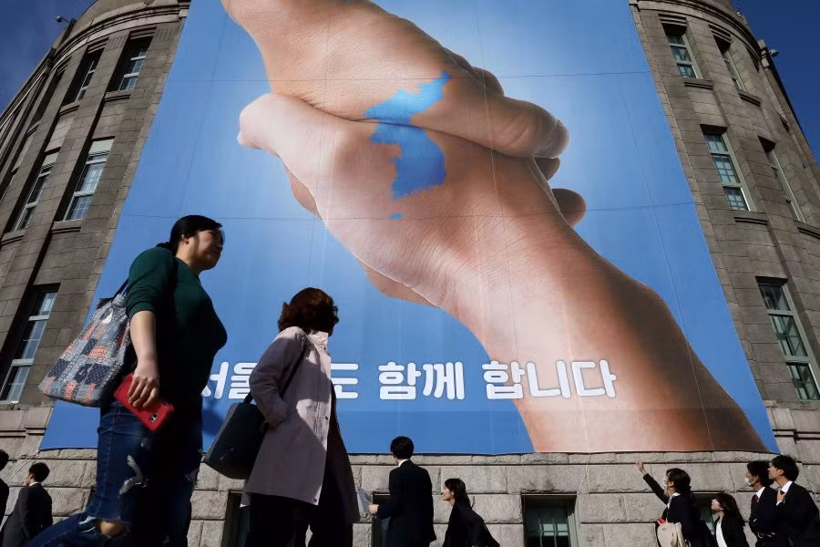 Banner cái bắt tay hữu nghị giữa hai nhà lãnh đạo liên Triều được treo trước cửa Toà thị chính Seoul.