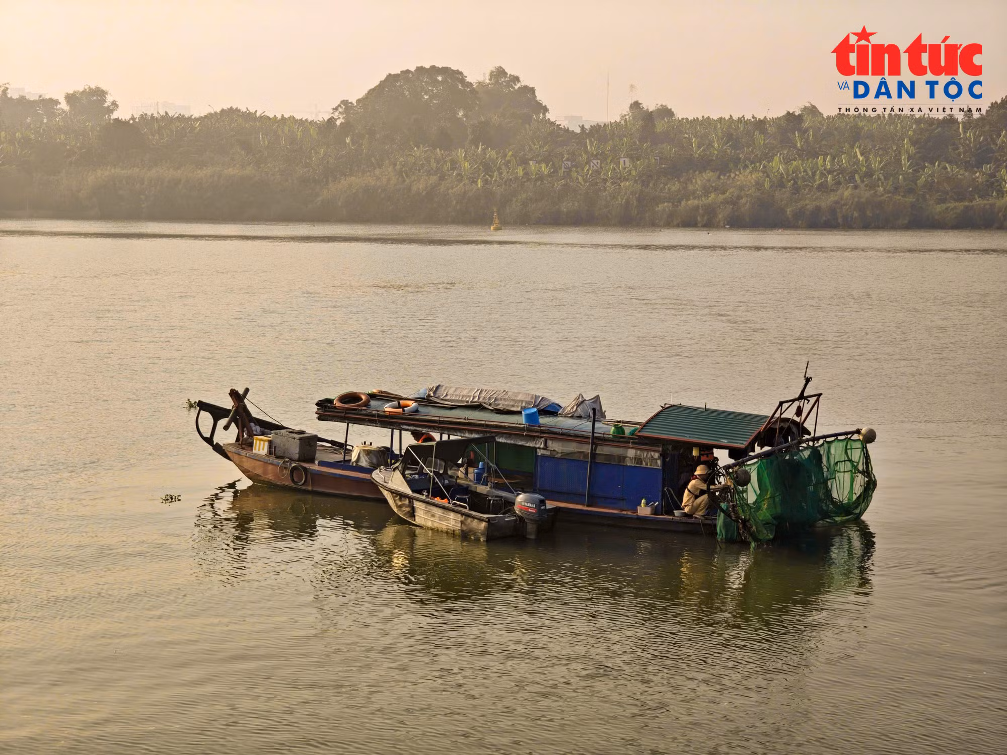 Thuyền cá thô sơ sử dụng kích điện để khai thác thủy sản trên sông Hồng.
