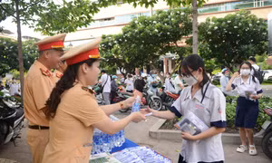 Lực lượng CSGT TP Hồ Chí Minh phát nước suối, bút... cho các thí sinh đến điểm thi tại Trường THPT Hùng Vương (Quận 5).