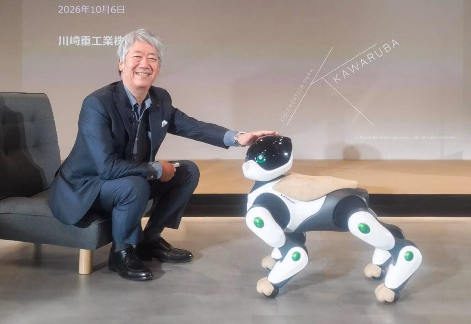 Chủ tịch Kawasaki Heavy Industries, ông Yasuhiko Hashimoto, chụp ảnh cùng nguyên mẫu robot hình chó "Home Leo" của công ty tại Tokyo. Ảnh: JIJI