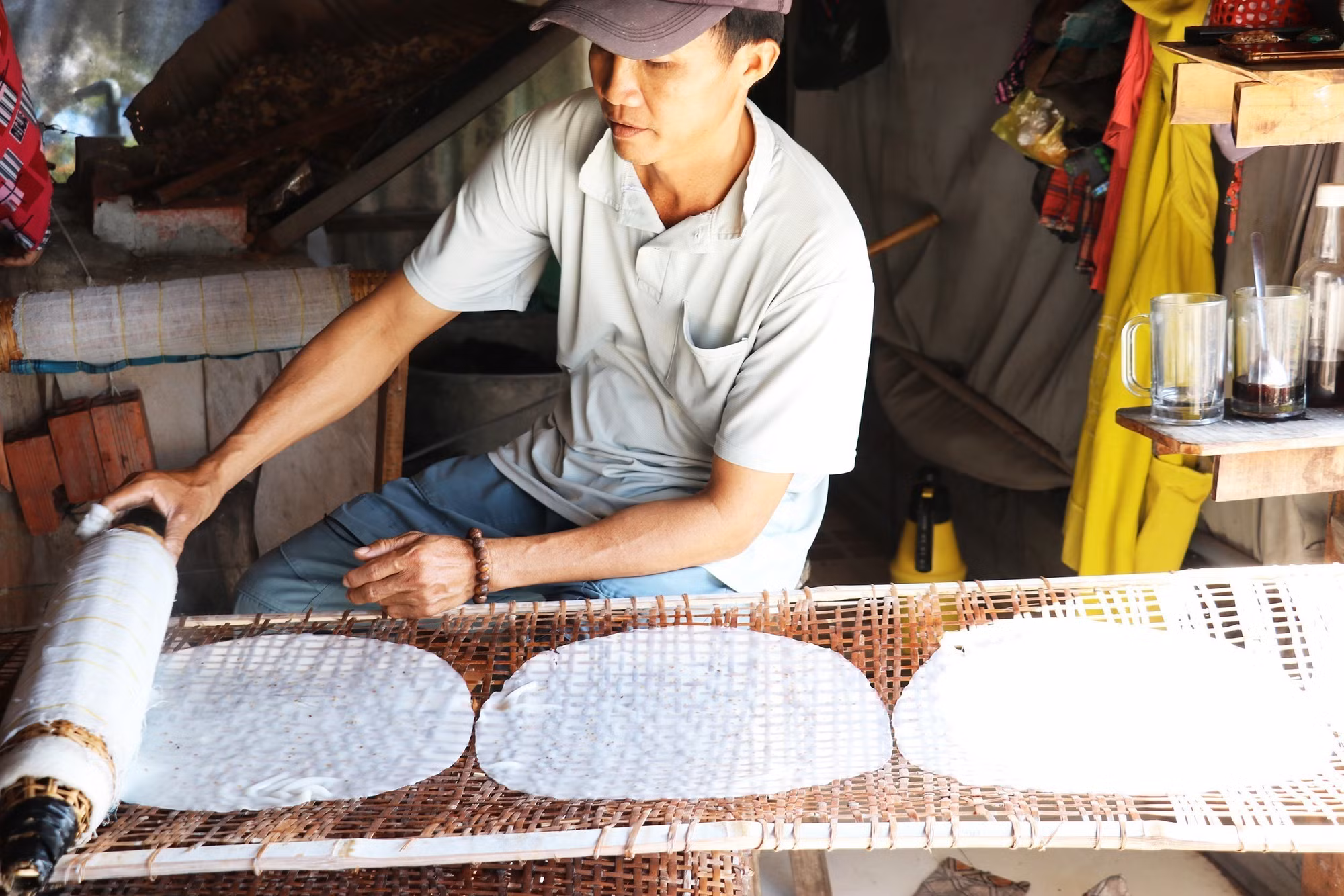 Anh Nguyễn Văn Tài ở ấp Hậu Thuận, xã Hậu Thành, huyện Cái Bè, tỉnh Tiền Giang đặt bánh vừa tráng vào vỉ để phơi khô. Ảnh: Hữu Chí – TTXVN